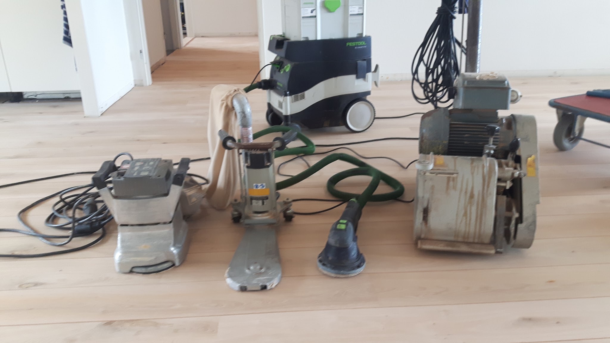 Schuurmachines en afzuiging op een lichte vloer